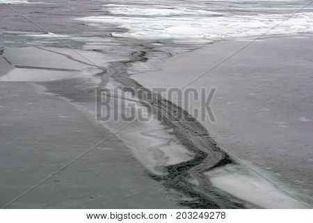 A crack forms on the thinning ice covering Little Traverse Bay, near Wequetonsing, Michigan, during March.