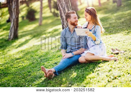 Beautiful couple studying together for exams in nature