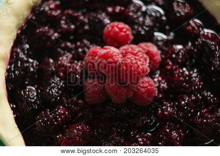 High anlge view of raspberries and blackberries on tart