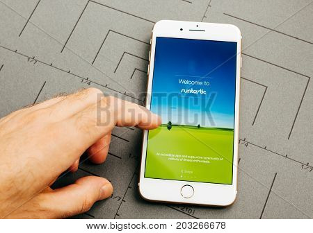 PARIS FRANCE - SEP 26 2016: Male hand holding New Apple iPhone 7 Plus after unboxing and testing by installing the app application software Runtastick sport tracking app for runners