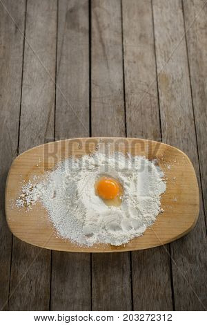 High anlge view of egg yolk in flour on cutting board at table