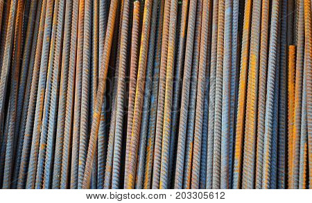 Reinforcing bar or rebar is a common steel bar that is hot rolled and is used widely in the construction industry especially for concrete. Steel Rebar Textured Background.