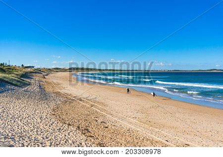 Sunny Beach With Two Unrecognisable Surfers