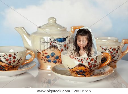 Partie de thé avec des tasses à thé antique et une fille de miniature comme dans alice au pays des merveilles
