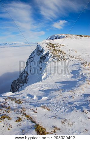 Mountain peak above the clouds. Sunny winter day on mountain above the clouds. Dry mountain in Serbia in winter with highest peak Trem