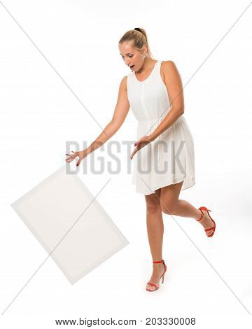 Young jocular woman portrait of a confident businesswoman showing presentation, pointing placard gray background. Ideal for banners, registration forms, presentation, landings, presenting concept.