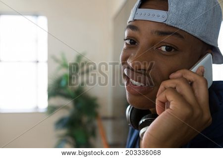 Portrait of male dancer talking on mobile phone in studio