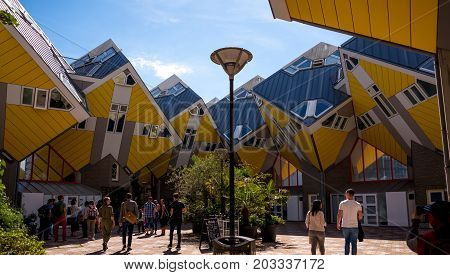 ROTTERDAM NETHERLANDS - AUGUST 13 2017 : Group of tourists in the yard of Cube houses or Kubuswoningen in Dutch are a set of innovative houses designed by architect Piet Blom