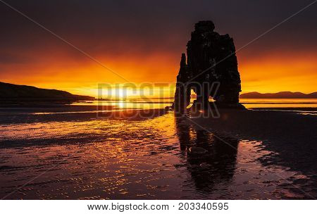 Is a spectacular rock in the sea on the Northern coast of Iceland. Legends say it is a petrified troll. On this photo Hvitserkur reflects in the sea water after the midnight sunset
