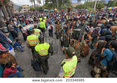 June 29 2017 Cotacachi Ecuador: police walking tjrough indigenous Kichwa crowd on the street celebrating Inti Raymi