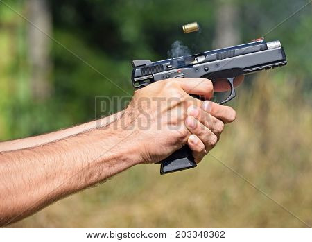 Shooting hand with a handgun pistol outdoor