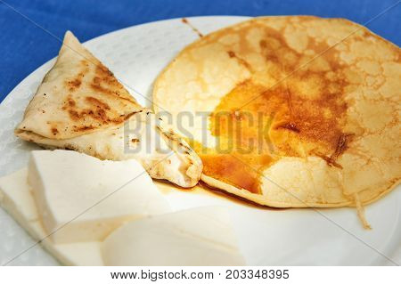 Syrniki laying on a plate isolated over white background