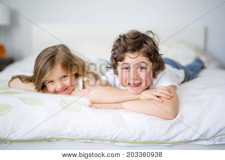 A Brother And Sister Relaxing Together In Bed