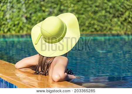 Women lifestyle relaxing near luxury swimming pools sunbath at home summer day at the beach resort in the hotel. Summer Concept