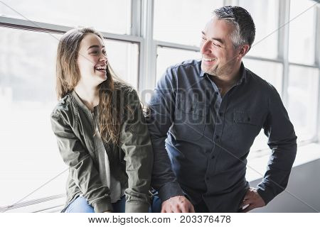 A nice and cool Teenager girl sitting on window with father