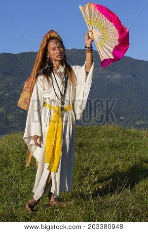 Shemale Sirena Sabiha dancing with a fan at sunrise in Pokhara Nepal. Sirena was born in the Philippines. Close up