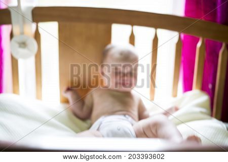 A blurred image of a crying baby girl in bedroom