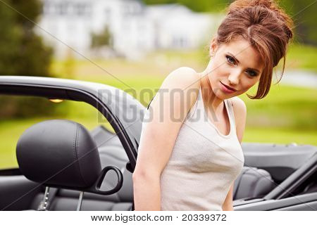 Mujer sexy posando junto al coche cabrio