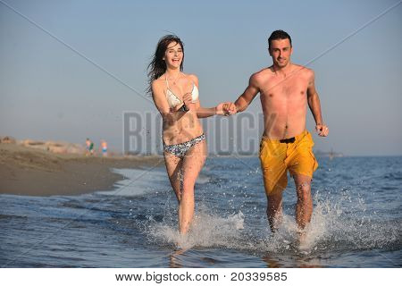 Szczęśliwa młoda para miłej zabawy i romantyczne chwile na plaży w sezonie letnim i reprezentujących happynes