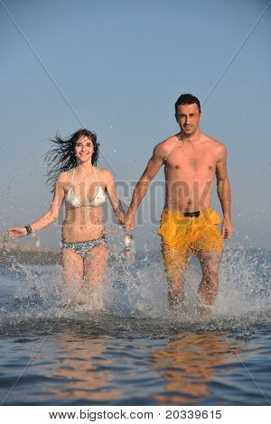 Szczęśliwa młoda para miłej zabawy i romantyczne chwile na plaży w sezonie letnim i reprezentujących happynes