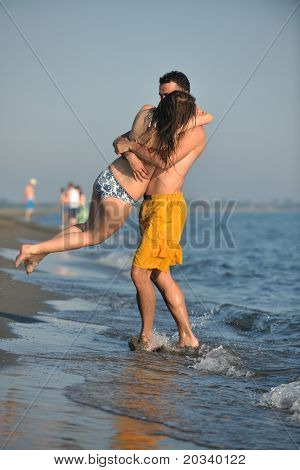 Szczęśliwa młoda para miłej zabawy i romantyczne chwile na plaży w sezonie letnim i reprezentujących happynes