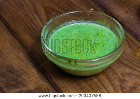 Sauce in a glass bowl on a background of a board