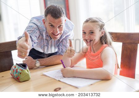 A Male Home Tutor Helping Teenage Girl With Studies