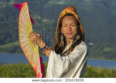 Shemale Sirena Sabiha dancing with a fan at sunrise in Pokhara Nepal. Sirena was born in the Philippines. Close up