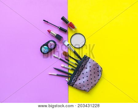 Cosmetics and fashion background with make up artist objects: lipstick eye shadows mascara eyeliner concealer nail polish. Pink and yellow colorfull Background. Lifestyle Concept