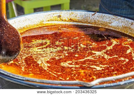 Tasty goulash in stew pot. Food theme. Summer garden party.