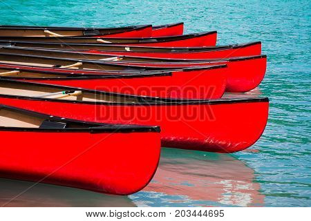 Row of red canoes in lake calm water