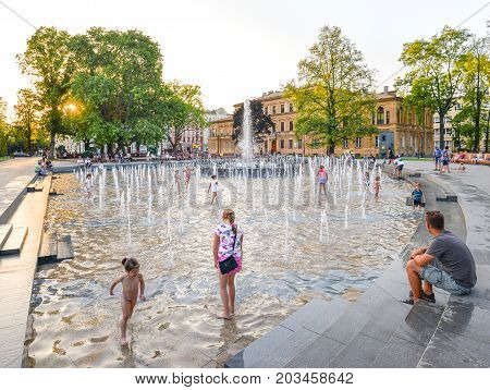 Lublin, Poland - August 11, 2017: Multimedia Lublin Fountain, Lithuanian Square, Lublin, Poland. Children playing in beautiful modern fountain in park, Lublin