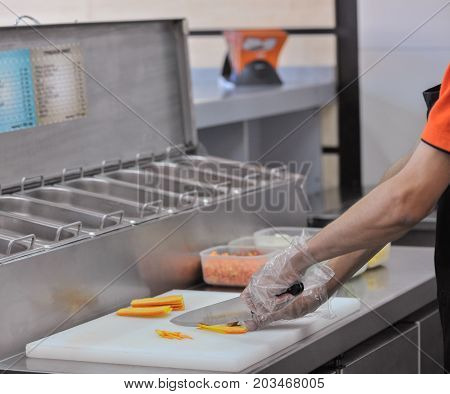 Chef cuts the vegetables in fast food restaurant. cook in the kitchen of the restaurant cut carrots for salad