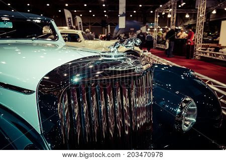 MAASTRICHT NETHERLANDS - JANUARY 09 2015: Hood ornament of a British two-door sports saloon Jaguar Mk IV 35 litre Drop Head Coupe Vanden Plas 1947. Vintage toning. Stylization. International Exhibition InterClassics & Topmobiel 2015