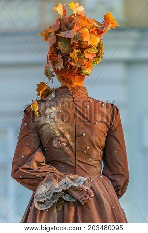 TIMISOARA ROMANIA - SEPTEMBER 8 2017: Living statue of a woman dressed with autumn elements and present on the street inside the CheckART Carnival organized by the City Hall Timisoara. Union Square.