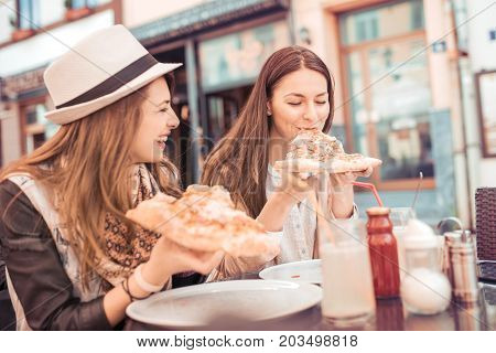 Two young women having lounch break after good shopping.