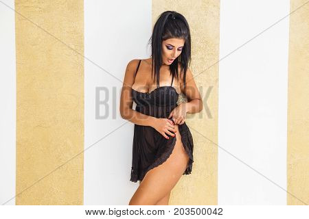 Beautiful girl brunette in lingerie posing in the interior of the apartment