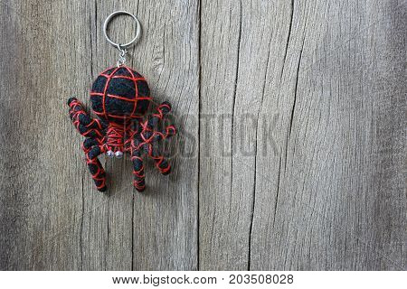 Key chain spider on old wooden background and have copy space for design in your work backdrop.