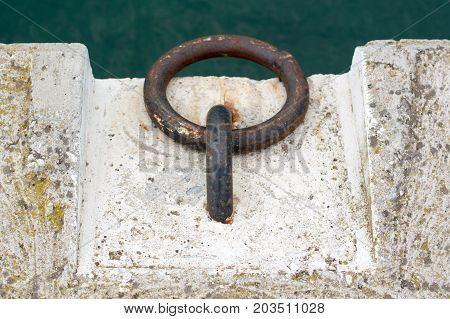 Dock Cleats On A Pier To Tie-up Boats With Green Sea As The Background