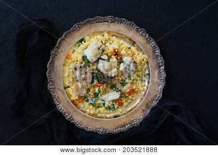 Couscous with fish and vegetables on sto