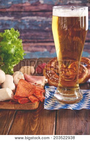 Vertical shot of Oktoberfest food, consisting of white sausages, pretzles and beer. Copy space.