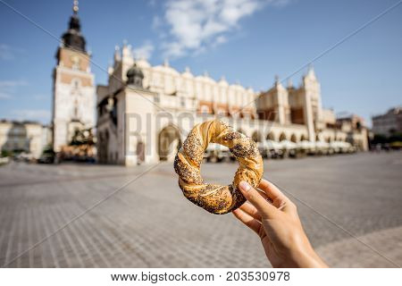 Holding prezel, traditional polish snack on the Market square in Krakow