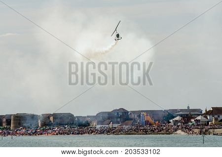 Clacton Essex United Kingdom -25 August 2017: Gyro copter flying over Clacton Essex in annual free air display with crowd in background