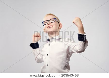 Happy caucasian blond boy in glasses is glad with win. Handsome child is proud of himself isolated on white background.