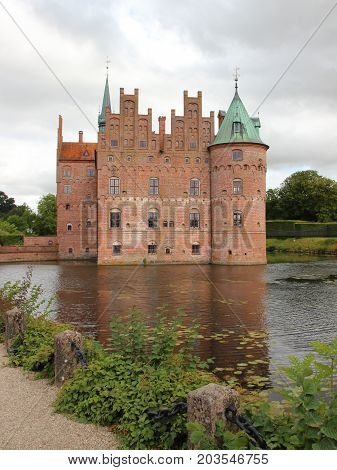 Egeskov Castle Denmark and Pond with Overcast Sky