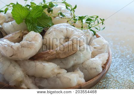 Raw fresh shrimps in a  wooden plate.