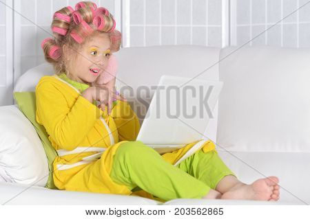 Portrait of a cute little girl using laptop