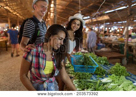 Group Of People Choosing Potherbs On Street Market Happy Smiling Friends Buy Products Together Shopping On Asian Bazaar
