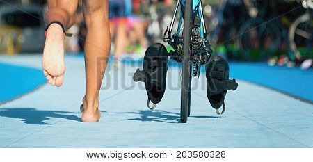 Triathlon bike the transition zone, the triathlonist runs on a bicycle