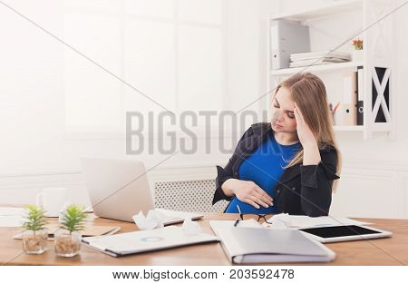 Tired pregnant businesswoman at office copy space. Expectant business lady feeling sick at work, gestosis concept